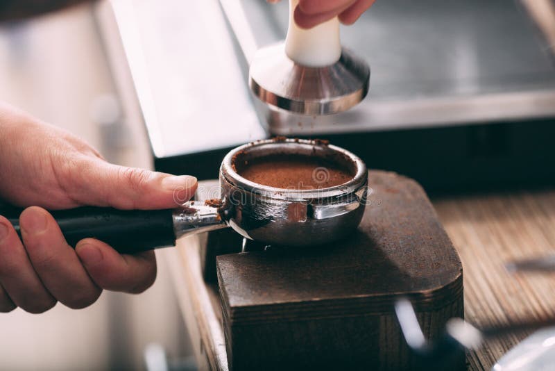 Barista que presiona el café en el tenedor de la máquina fotografía de archivo