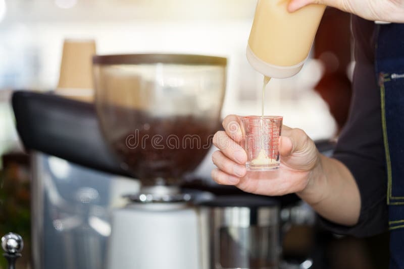 Barista`s Hand is Pouring Milk in a Measuring Cup Stock Image Image