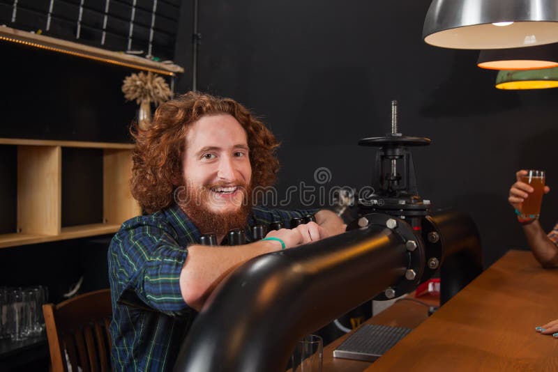 Barista sorridente felice Stand At Counter, barista Waiting Order Serving, posto di lavoro del rubinetto della birra delle mani immagine stock Barista sorridente felice Stand At Counter, barista Waiting Order Serving, posto di lavoro del rubinetto della birra delle mani immagine stock