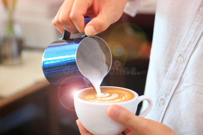 Barista usando la jarra para verter la leche espumejeada para ahuecar de modelo del tulipán del latte del café en el top imagen de archivo Barista usando la jarra para verter la leche espumejeada para ahuecar de modelo del tulipán del latte del café en el top imagen de archivo