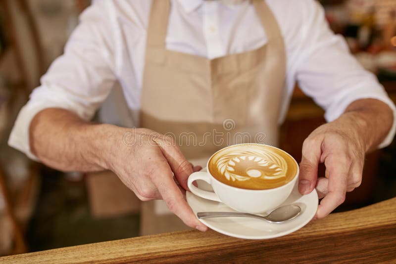 Barista vi che dà una tazza di caffè fresco fotografia stock