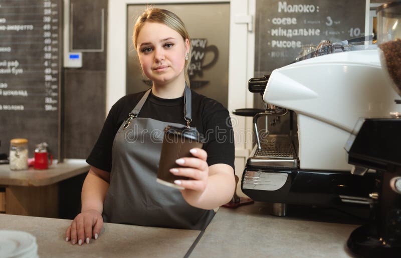 Barista Woman Gives a Glass of Coffee while Standing at the Counter in