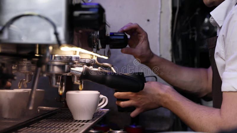 Barista που προετοιμάζει τον καφέ στη μηχανή καφέ στην κινηματογράφηση σε πρώτο πλάνο καφέδων