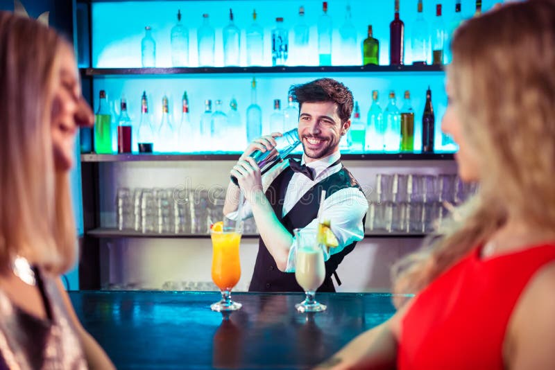 Barkeeper que prepara o cocktail para clientes fêmeas imagens de stock Barkeeper que prepara o cocktail para clientes fêmeas imagens de stock