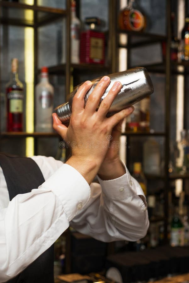 Barman au travail, préparant des cocktails Secousse du dispositif trembleur de cocktail photo stock Barman au travail, préparant des cocktails Secousse du dispositif trembleur de cocktail photo stock