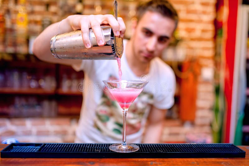 Barman die en kosmopolitische alcoh voorbereidt giet stock afbeeldingen Barman die en kosmopolitische alcoh voorbereidt giet stock afbeeldingen