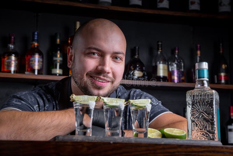 Barman die harde geest gieten in kleine glazen zoals alcoholische schoten van tequila of sterke drank royalty-vrije stock foto Barman die harde geest gieten in kleine glazen zoals alcoholische schoten van tequila of sterke drank royalty-vrije stock foto