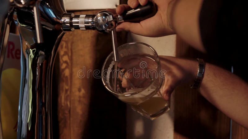 barman die vers koud bier in een glas gieten