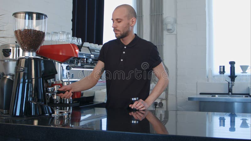 Barman masculin utilisant la machine de café préparant le café pour un client image stock Barman masculin utilisant la machine de café préparant le café pour un client image stock