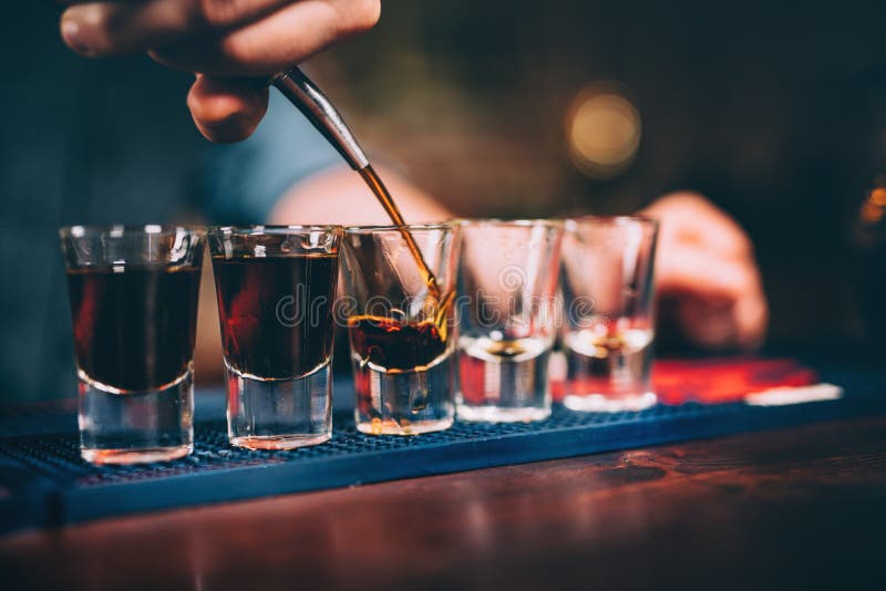 Barman pouring and serving alcoholic drinks at bar. Barman pouring and serving alcoholic drinks at bar