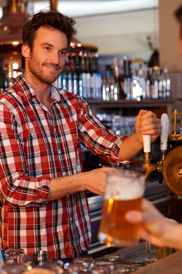 Barman tapant la bière fraîche dans le bar photos libres de droits Barman tapant la bière fraîche dans le bar photos libres de droits