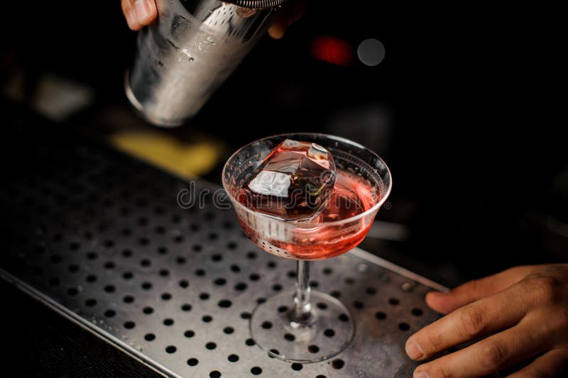 Barmixer, der Campari-Alkohol vom Schüttel-Apparat in das Cocktailglas gießt stockfotos Barmixer, der Campari-Alkohol vom Schüttel-Apparat in das Cocktailglas gießt stockfotos