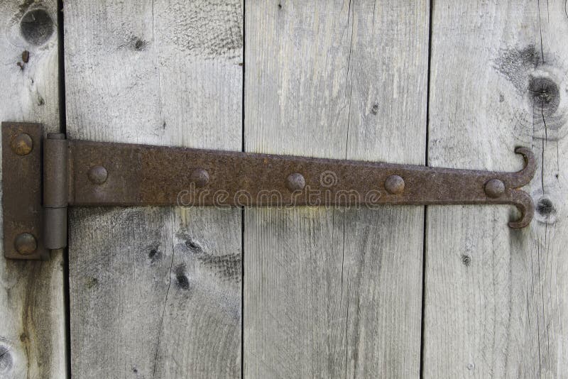 Vertical image of grey barn door with rusted hinge. Vertical image of grey barn door with rusted hinge