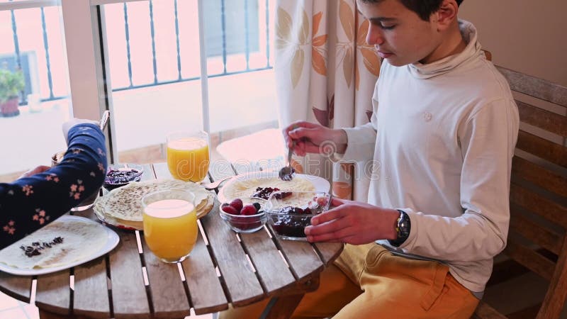 Barn får pannkakor med toppar för rovdagsfrukost arkivfilmer