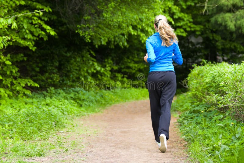 Young woman running around the park alley. Young woman running around the park alley