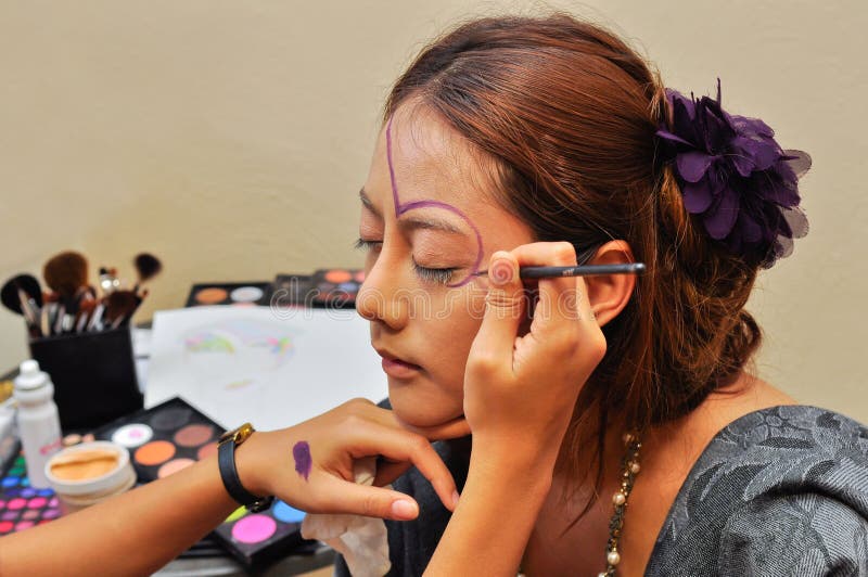Barn för kvinna för beauticianmodesmink. Den applicerade beauticianen som den härliga finalen som har henne, gör, trycker på upp kvinnabarn
