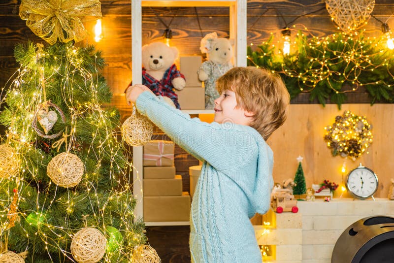 Barn i vinterklänningen som dekorerar julgranen med bubblor Kid som dekorerar julgranen och har kul royaltyfria foton Barn i vinterklänningen som dekorerar julgranen med bubblor Kid som dekorerar julgranen och har kul royaltyfria foton