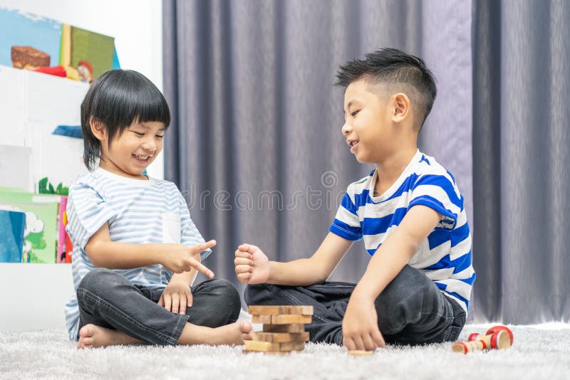 Barn leker med en leksaksdesigner på golvet i barnens rum Två barn leker med färgblock Kindergarten pedati royaltyfria bilder