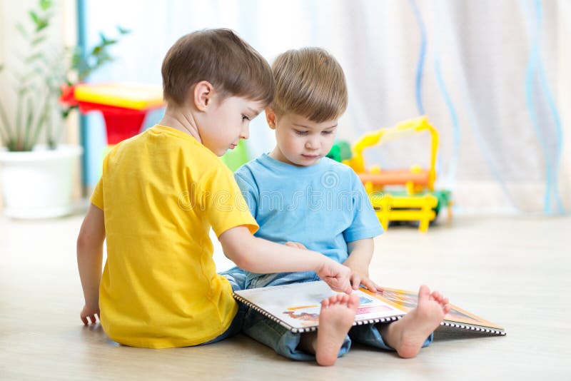 Barn läste ett boksammanträde på golv hemma