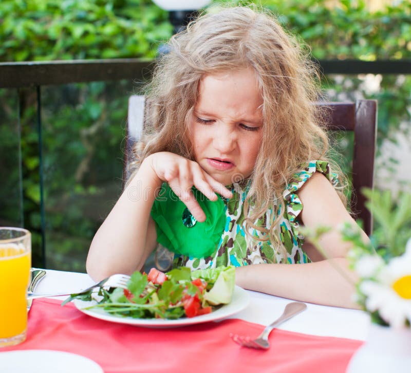 Barn med avsmak som ser sallad royaltyfria foton Barn med avsmak som ser sallad royaltyfria foton