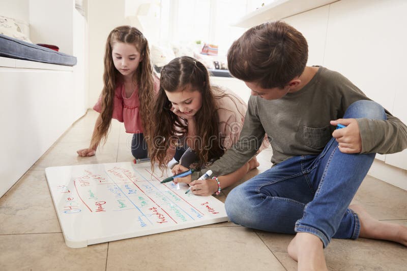 Children Making List Of Chores On Whiteboard At Home. Children Making List Of Chores On Whiteboard At Home