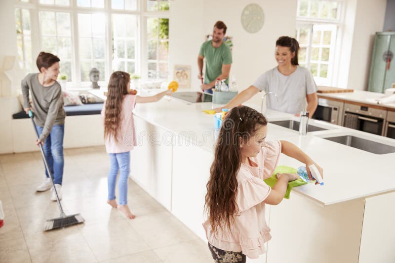 Children Helping Parents With Household Chores In Kitchen. Children Helping Parents With Household Chores In Kitchen