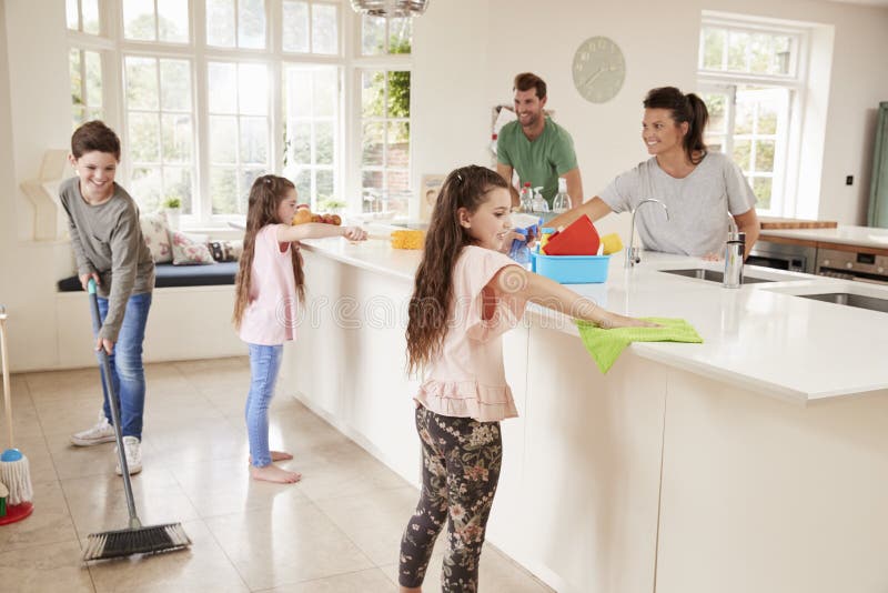 Children Helping Parents With Household Chores In Kitchen. Children Helping Parents With Household Chores In Kitchen