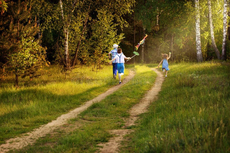 Barn som kör på naturen på solnedgången med strålen av ljus royaltyfri bild Barn som kör på naturen på solnedgången med strålen av ljus royaltyfri bild