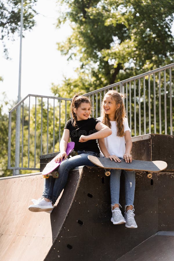 Barn som leker och skrattar och har kul tillsammans. barn med skateboard och penny board kommunicerar och diskuterar royaltyfri foto