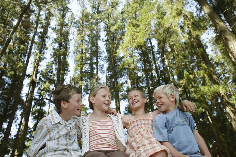 Barn som omkring sitter armen i skog royaltyfri foto Barn som omkring sitter armen i skog royaltyfri foto