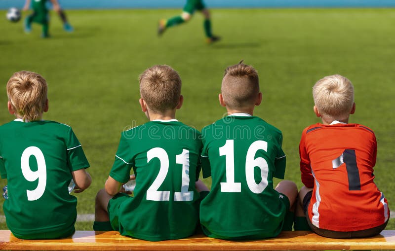 Barn som sitter på fotbollfotbollträbänk Ungar Junior Football Team arkivfoton Barn som sitter på fotbollfotbollträbänk Ungar Junior Football Team arkivfoton