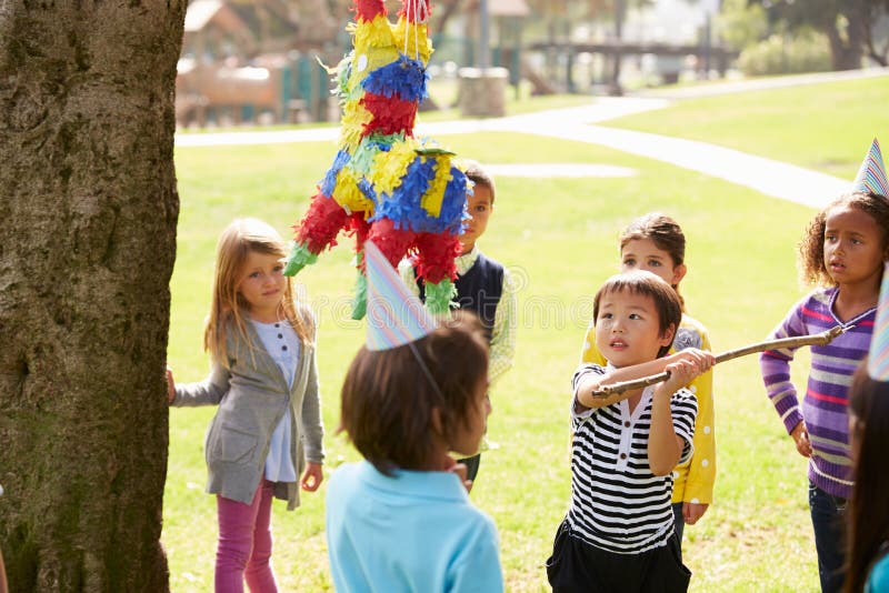 Barn som slår Pinata på födelsedagpartiet royaltyfria bilder Barn som slår Pinata på födelsedagpartiet royaltyfria bilder