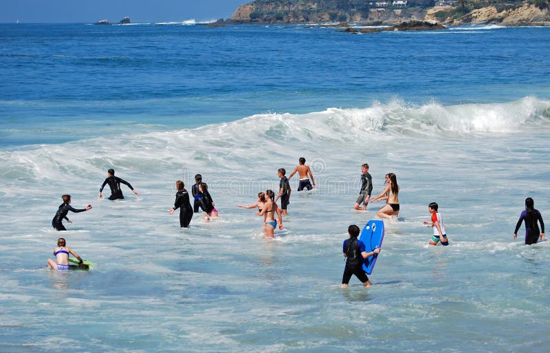 Barn som spelar i bränningen av den sömniga ihåliga stranden i Laguna Beach, Kalifornien royaltyfri fotografi Barn som spelar i bränningen av den sömniga ihåliga stranden i Laguna Beach, Kalifornien royaltyfri fotografi