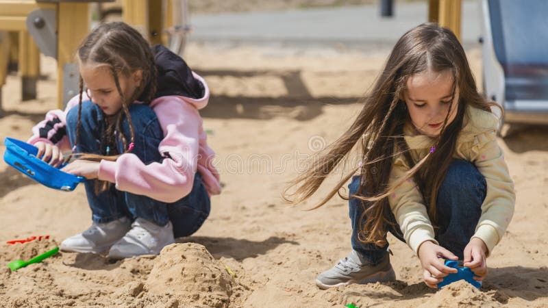 Barn som spelar sand på lekplats arkivbild
