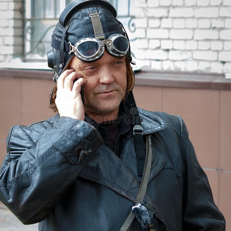 Barnaul, Russia, il 9 maggio 2018: Giorno di vittoria Un uomo in una vecchia uniforme del cuoio di un pilota, un aviatore degli a fotografie stock libere da diritti Barnaul, Russia, il 9 maggio 2018: Giorno di vittoria Un uomo in una vecchia uniforme del cuoio di un pilota, un aviatore degli a fotografie stock libere da diritti