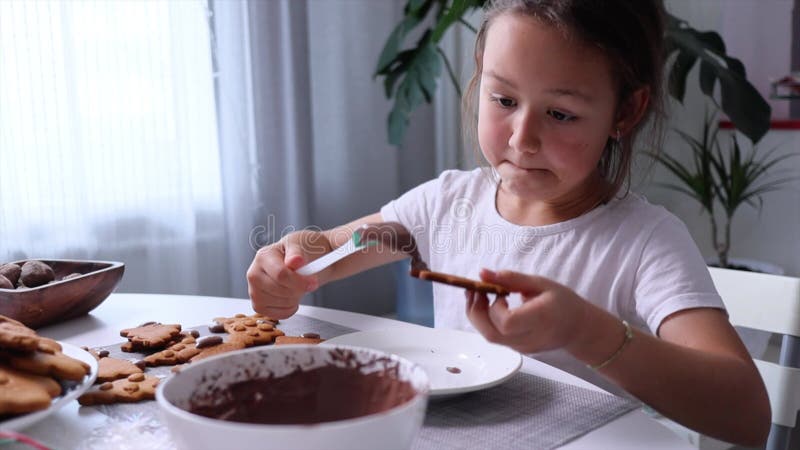 Barnet dekorerar kakor för gingerbröd under semestern