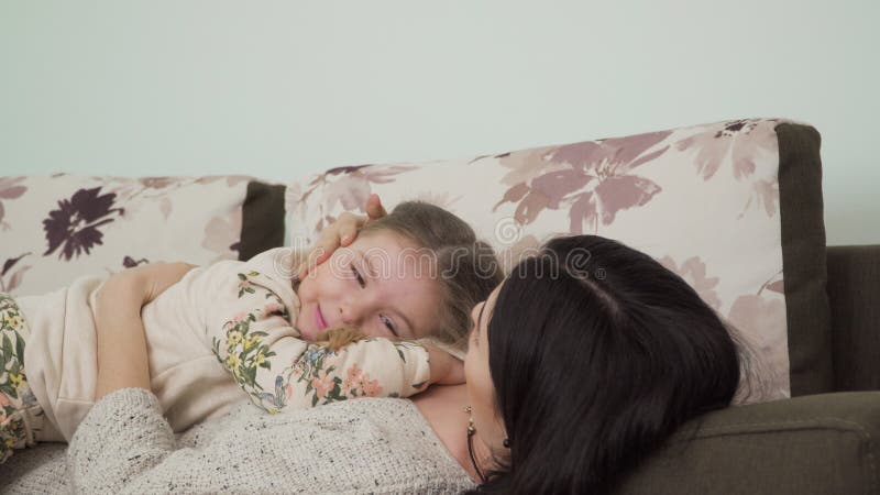 Barnet fostrar med den lilla dottern kopplar av på soffan hemma