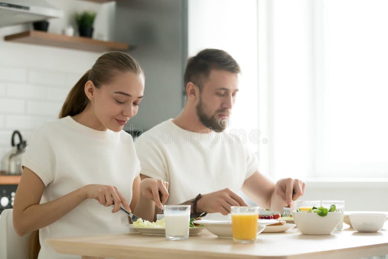 Barnet kopplar ihop att ha matställen och att smaka frukosten som tillsammans äter a royaltyfri fotografi Barnet kopplar ihop att ha matställen och att smaka frukosten som tillsammans äter a royaltyfri fotografi