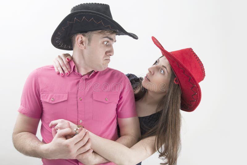 Barnet kopplar ihop med cowboyhattar som gör enfaldiga framsidor på vit royaltyfri bild Barnet kopplar ihop med cowboyhattar som gör enfaldiga framsidor på vit royaltyfri bild