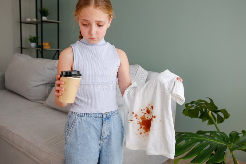 The child spilled coffee on his clothes. The concept of a stain on a t-shirt. The child spilled coffee on his clothes. The concept of a stain on a t-shirt.