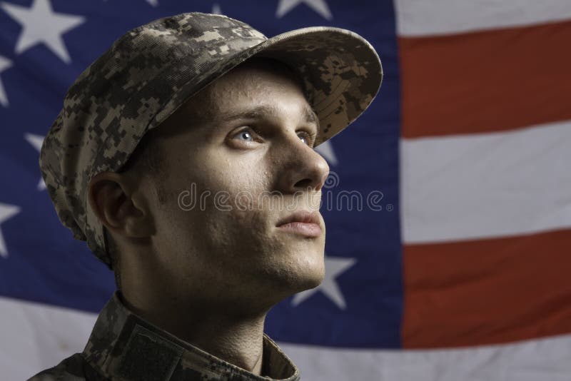 Barnet tjäna som soldat poserat framme av amerikanska flaggan, horisontal arkivbild Barnet tjäna som soldat poserat framme av amerikanska flaggan, horisontal arkivbild