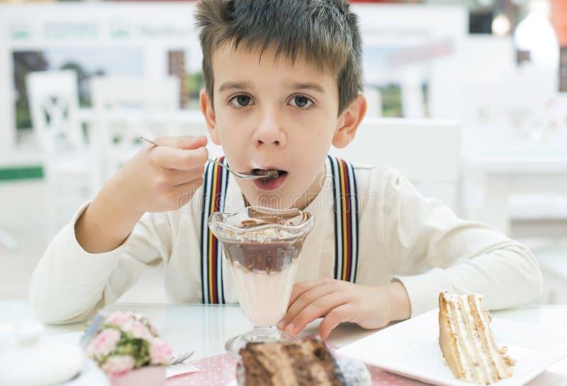 Barnet äter mjölkar chocoskakan arkivfoton Barnet äter mjölkar chocoskakan arkivfoton