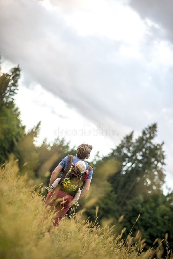 Barnfader som bär hans son på hans baksida, som de går thorugh a arkivfoto