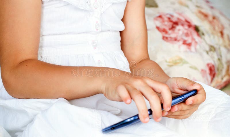 Barnflickainnehav och pekskärm av den smarta telefonen royaltyfri fotografi Barnflickainnehav och pekskärm av den smarta telefonen royaltyfri fotografi