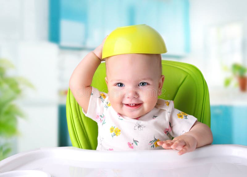 Baby food,nutrition concept.Child sitting at table with bowl over head.Kid girl eating. Baby food,nutrition concept.Child sitting at table with bowl over head.Kid girl eating.