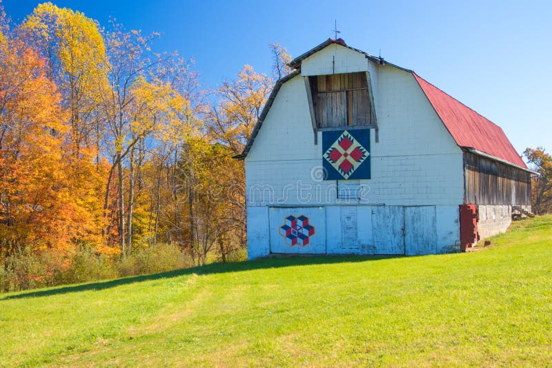 White barn with a red roof with quilts on a clear sunny day. White barn with a red roof with quilts on a clear sunny day