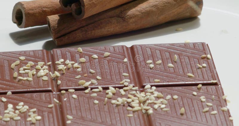 Barra de chocolate e varas de canela escuras com sementes de sésamo