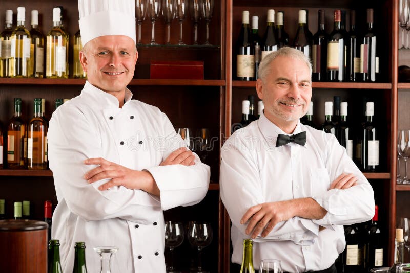Barra de vinho do restaurante do cozinheiro e do empregado de mesa do cozinheiro chefe foto de stock Barra de vinho do restaurante do cozinheiro e do empregado de mesa do cozinheiro chefe foto de stock