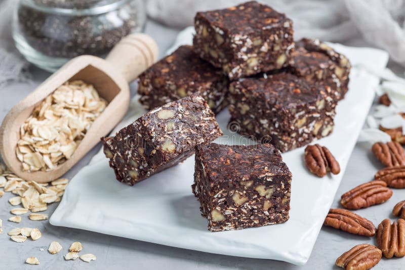 Barras de energía del chocolate de Paleo con la avena rodada, las nueces de pacana, las fechas, las semillas del chia y las escam foto de archivo Barras de energía del chocolate de Paleo con la avena rodada, las nueces de pacana, las fechas, las semillas del chia y las escam foto de archivo