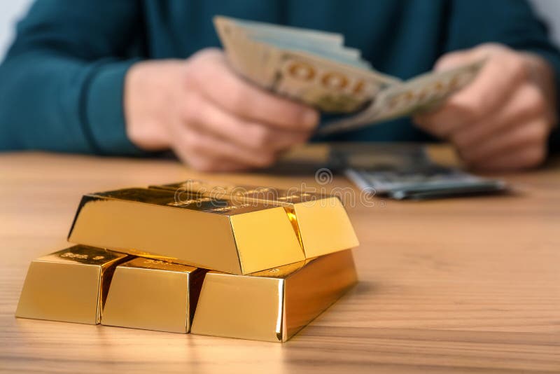 Barras y hombre de oro apiladas que cuentan el dinero, primer Espacio para el texto imagen de archivo